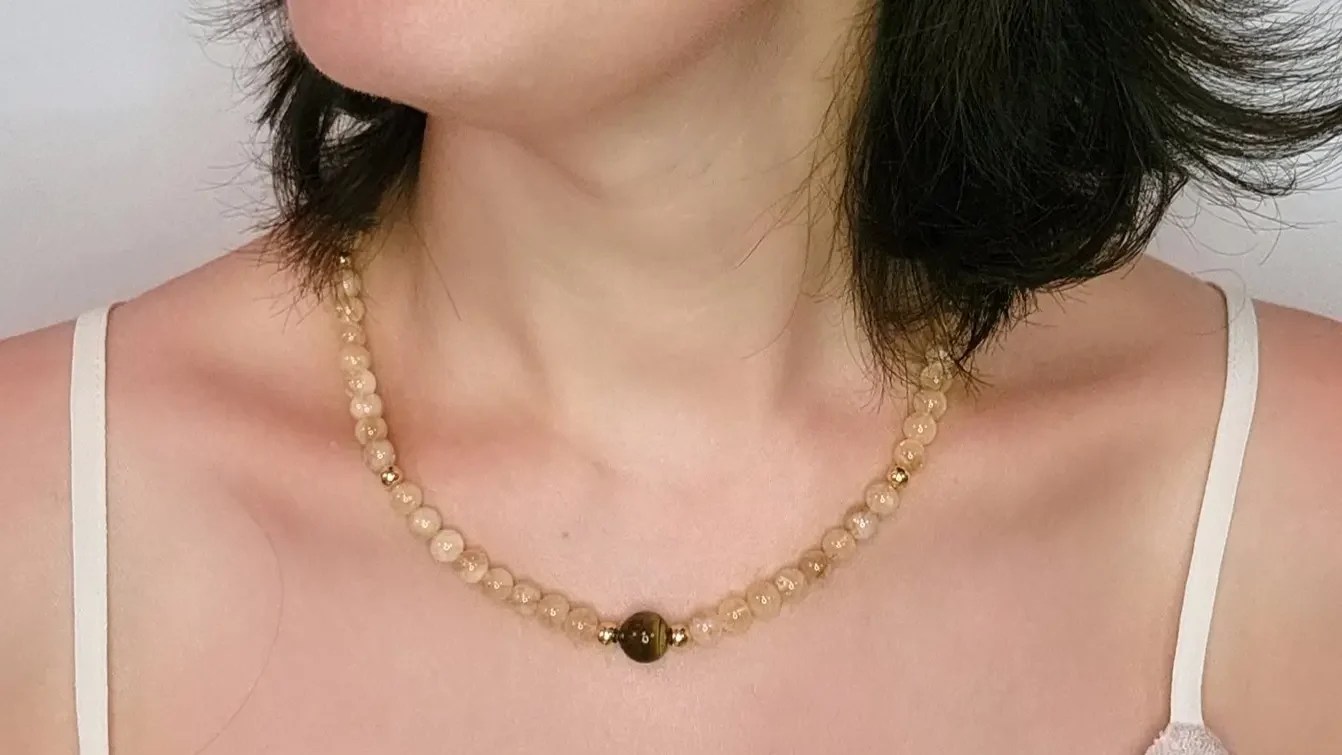 mulher usando colar com pedra citrino